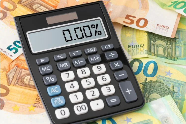 Une calculatrice affichant un taux zéro entouré de billet de 50 et 100 euros