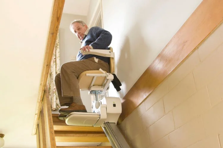 Une personne âgée assis dans un monte-escalier.