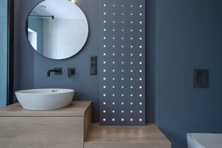 Miroir rond positionné dans une salle de bain