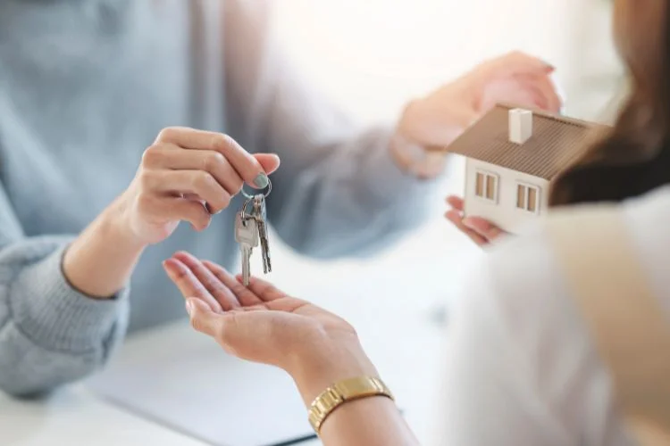 Un vendeur donne les clés d'un logement au nouveau propriétaire.