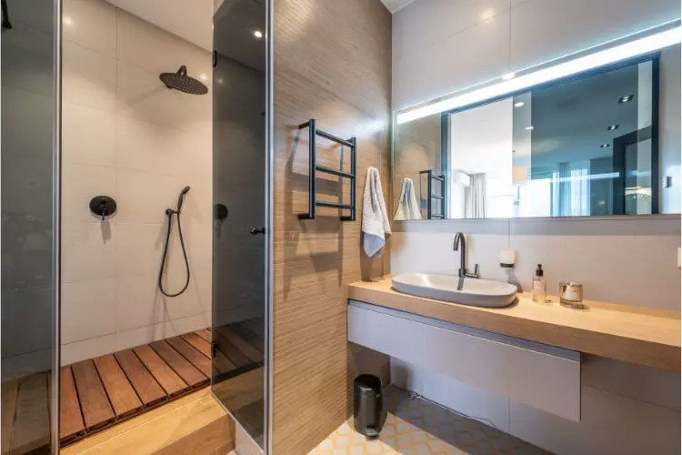 Salle de bain lumineuse, avec des spots au-dessus du miroir.