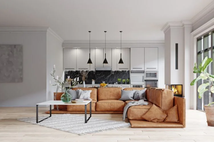 Salon ouvert moderne avec un canapé en cuir marron.