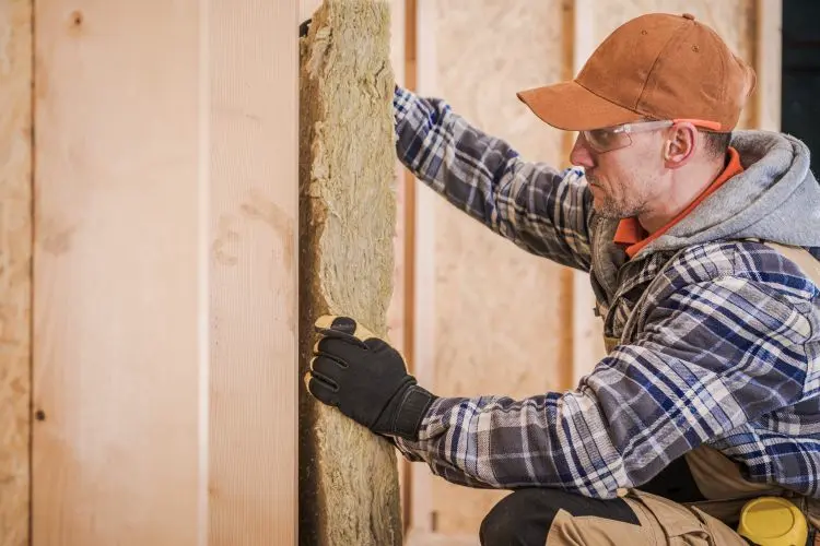 Un professionnel installe un isolant sur les murs intérieurs d'une maison