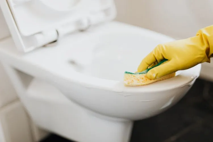 Une personne en train de laver ses toilettes.