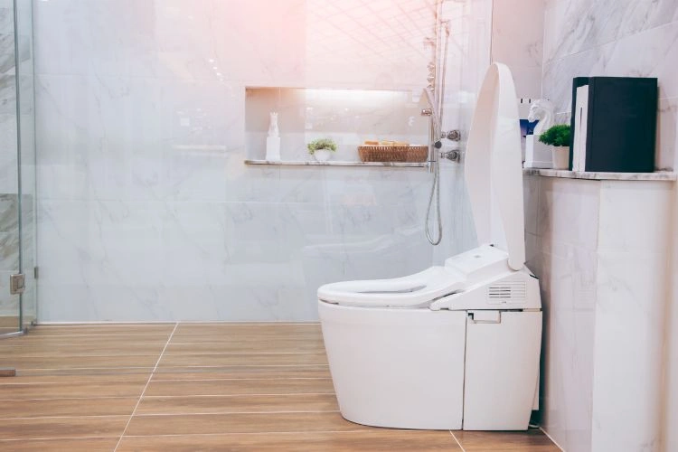 Wc blanc dans une salle de bain représentant un sanibroyeur