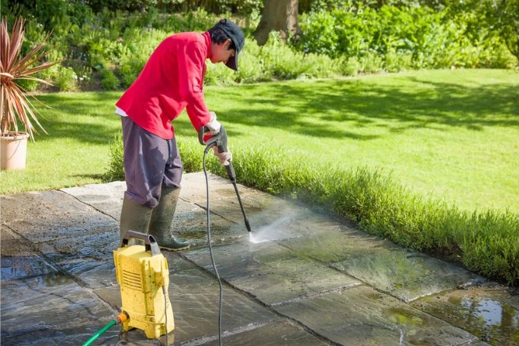 Personne en train de nettoyer une terrasse