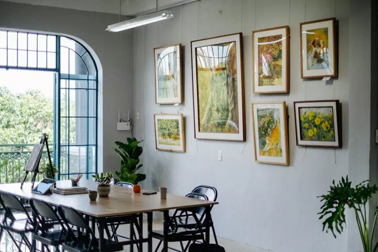 Salle à manger avec 7 tableaux sur un mur